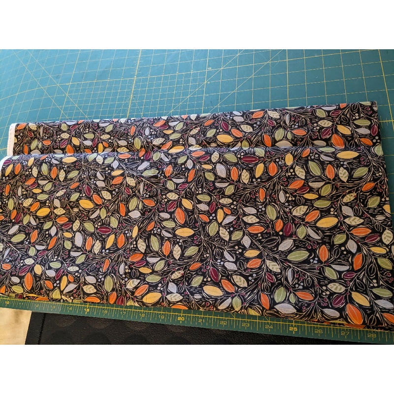 Cotton fabric black background with multiple colored leaves